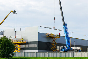 Sandwich panels wall assembly using telescopic boom crane and self propelled scissor lift platform © Zigmunds