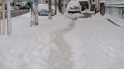 Fototapeta premium Path way made by people walking thru the snow in the morning. Path in heavy snow. Winter concept snow-path in the morning light