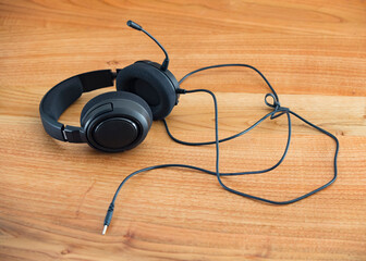Black headphones isolated on a wooden table.