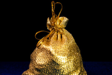 Golden bag with treasures on a dark background