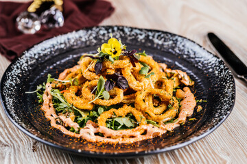 Deep Fried Crispy Calamari Fritti squid rings served in dish isolated on table side view of arabic appetizer food