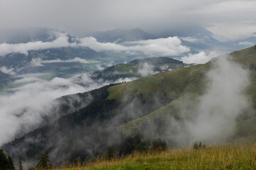 alpine valley view with clouds and fog