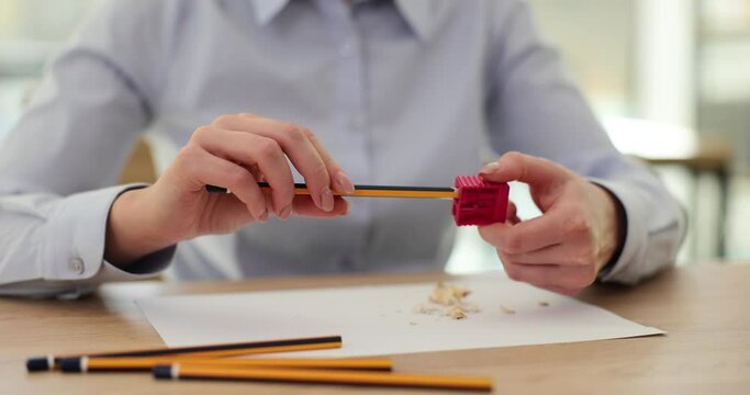 Employee sits at table with pencil and sharpener