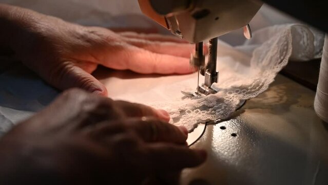 The work of the seamstress sews clothes and threads the fabric.
