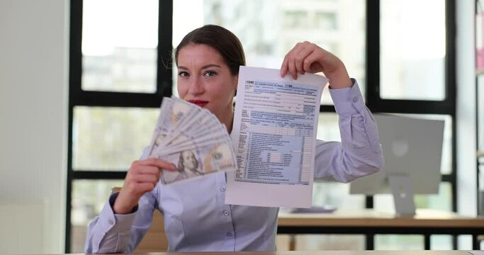 Businesswoman holding Form 1040 income tax return and dollar