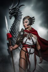 Fototapeta premium A fierce warrior woman stands with a spear before a menacing dragon, exuding confidence and strength against a stormy backdrop