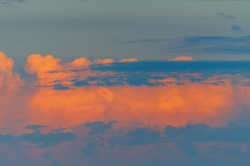 Clouds with unrealistically bright orange blue colors at sunset. Evening shades, atmospheric...
