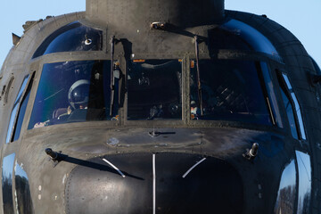 Vista frontal de la cabina de un helicóptero militar con sus pilotos en el interior durante unas maniobras militares. - obrazy, fototapety, plakaty