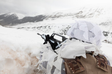 Un soldado de alta montaña con su fusil camuflado en un paisaje de montaña nevado. - obrazy, fototapety, plakaty
