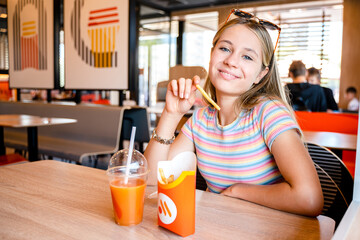 Young girl teenager eating fast food in Russian Mcdonald's Restaurant Vkusno I Tochka. Togliatti,...