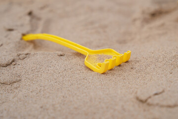 Fototapeta na wymiar Children's yellow shovel on the beach