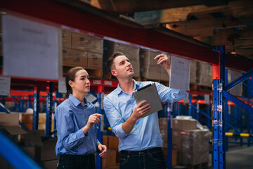 Worker in the warehouse checking the stock is on the shelves at the manufacturing. Engineer is working in the warehouse.
