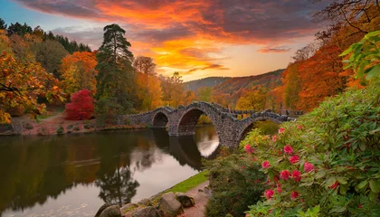 Foto auf Acrylglas Rakotzbrücke fantastic autumn landscape amazing sunset with colorful sky in azalea and rhododendron park kromlau rakotz bridge rakotzbrucke devil s bridge in kromlau saxony germany