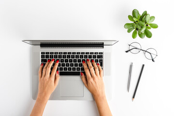 Woman’s hands working on laptop. Business background with accessories. Top view