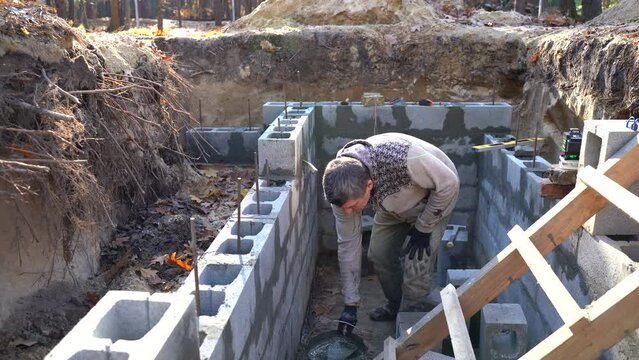 A real builder or mason building a basement wall