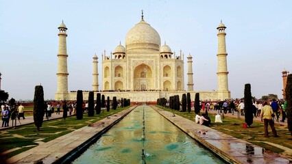 a building with many people near it and a water feature
