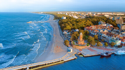 Port and lighthouse in Kołobrzeg, Poland. Photo taken with a drone at the beginning of autumn. The rippling, blue Baltic Sea.
