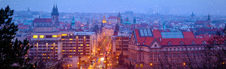 Prague Czech Republic. Wide panorama. Panoramic view at nighttime winter old town with falling...