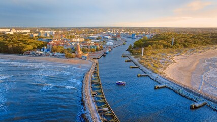 Port and lighthouse in Kołobrzeg, Poland. Photo taken with a drone at the beginning of autumn. The rippling, blue Baltic Sea. - obrazy, fototapety, plakaty
