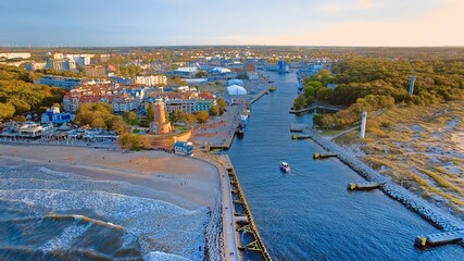 Port and lighthouse in Kołobrzeg, Poland. Photo taken with a drone at the beginning of autumn. The rippling, blue Baltic Sea. - obrazy, fototapety, plakaty
