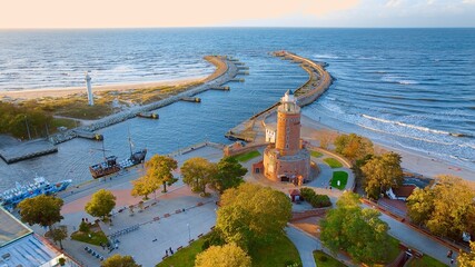 Port and lighthouse in Kołobrzeg, Poland. Photo taken with a drone at the beginning of autumn. The rippling, blue Baltic Sea.