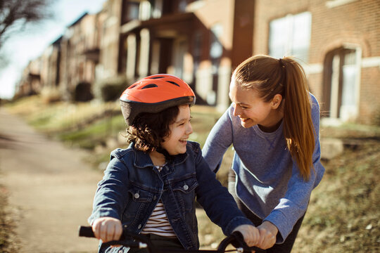 Loving mother teaching little son to ride a bike