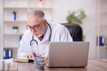 Old male doctor working in the clinic