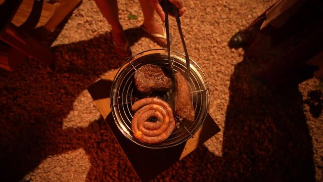 Churrasco sendo feito ao lado da fogueira