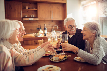 Smiling senior people toasting with wine on dining table