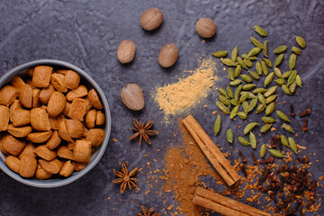 Flat lay of spices on a dark background. Top to bottom Nutmeg, White pepper, Cardamom, Cloves, Star Anise, Cinnamon.