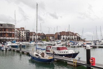 Fototapeta na wymiar Sailing yachts and pleasure motor boats are moored in Southampton marina, UK