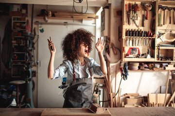 Craftswoman Grooving to Music in a Woodworking Workshop