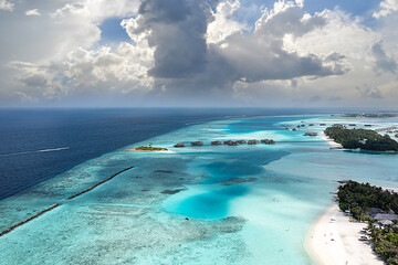 Top view of Maldives (Maldive)  island, with white sandy tropical exotic beach and turquoise colored sea with palm trees. Drone shooting