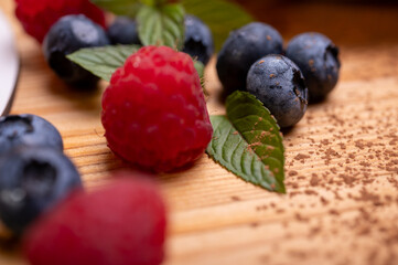 close-up of cheesecake decorated with fresh berries, blueberries and raspberries and mint leaves. confectionery, baking, bright colors