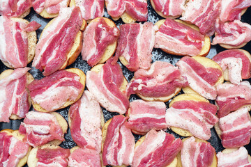 Raw potatoes with bacon, prepared for baking in the oven