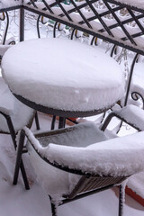 Snow-covered table and chairs on the balcony. First snow.