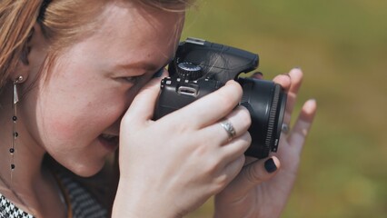 A girl taking pictures with her camera on a summer day.