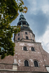 Fototapeta na wymiar High old tower landmark in a Cathedral with a beautiful old peak in Riga, Latvia