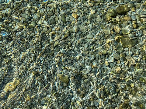 Clear sea water with pebbles at the bottom.