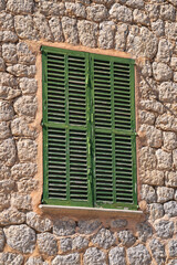 A small window with closed green shutters. Mallorca, Mediterranean Sea, Spain, Balearic Islands