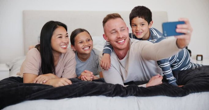 Selfie, happy family and together for picture in bedroom for memory, social media or post. Interracial, parent and kids with smile for bond, childhood or adoption in photo in excitement, love or care