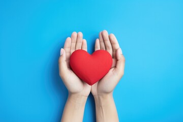 Obraz premium Woman Holding a Red Heart for Valentines Day on a Blue Background with Space for Copy