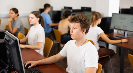 Fototapeta premium Portrait of male student at computer in university computer class