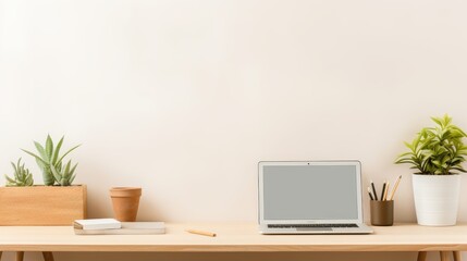 Obraz premium Neat workspace with an open laptop, succulents, and office supplies on a wooden desk.