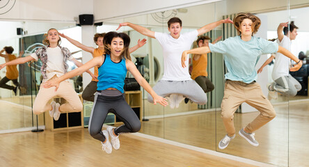 Group of happy teens jumping during exercising in choreography class