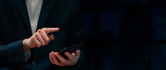 A businessman is using a mobile phone for business transactions, a man in a suit uses a mobile phone for financial transactions,Closeup body or businessman using smartphone in his hands