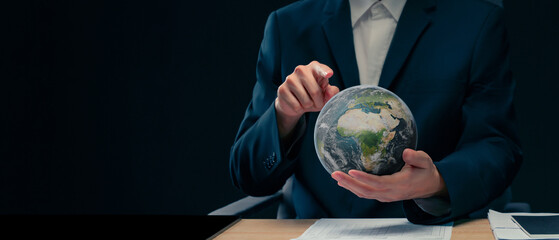 Concept image of a campaign to reduce the amount of greenhouse gases accumulated in the earth's atmosphere to zero, a businessman is holding a globe to raise awareness of doing business.