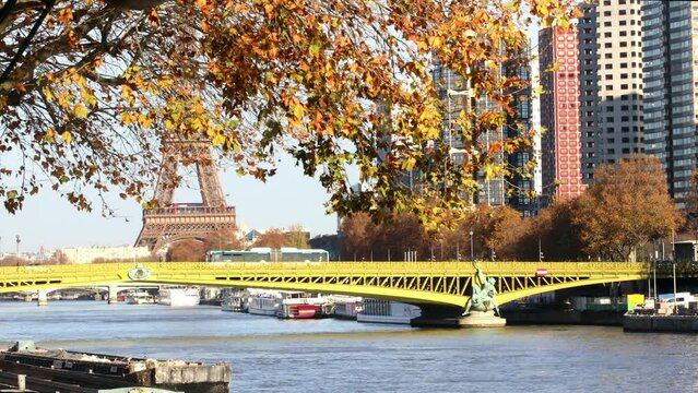 Eiffel tower over the river Seine with Mirabeau bridge and Statue of Liberty on a bright fall day in Paris, France