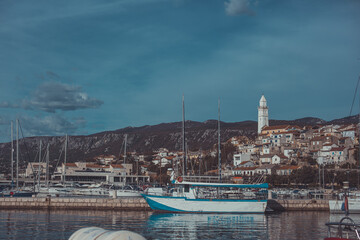 Panoramic view or cityscape of novi vinodolski at croatian kvarner coast. Sunny cityscape of houes at the adriatic sea, marina with boats in the foreground. - obrazy, fototapety, plakaty