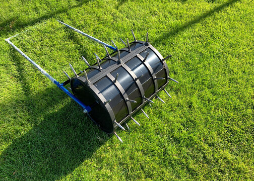 A view of special aerator for the handling and laying of the lawn on green grass. Garden machines concept.